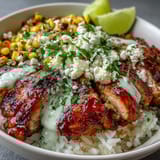 Garnished with crumbled cotija, fresh cilantro, and a drizzle of zesty crema, ready to squeeze lime wedges.