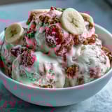 Frozen Strawberry & Banana Yoghurt Clusters on a tray with a creamy swirl and crunchy chips. 