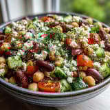 Creamy feta and briny olives top this Greek Bean Salad with lemon-marinated beans, cucumbers, and fresh herbs.
