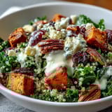 Bright lemon tahini dressing is drizzled over this colorful Harvest Kale Quinoa Bowl, featuring dried cranberries and crunchy pecans for a festive touch.