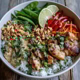 Colorful Thai Chicken Coconut Bowl served with lime wedges, offering a vibrant and aromatic meal for four.