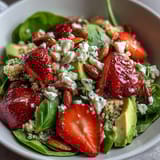 Refreshing quinoa salad with juicy strawberries, creamy avocado, and zesty lemon-maple dressing.  