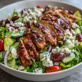 Refreshing Greek Salad Bowl with Grilled Chicken: colorful veggies, Kalamata olives, and tender grilled chicken in a zesty lemon-oregano dressing.