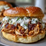 Juicy shredded chicken barbecue sandwich with tangy homemade white sauce on a bun.