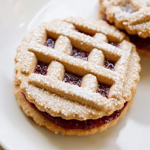 Butter and almond flavors burst from these homemade Linzer Cookies with beautifully cut-out tops.