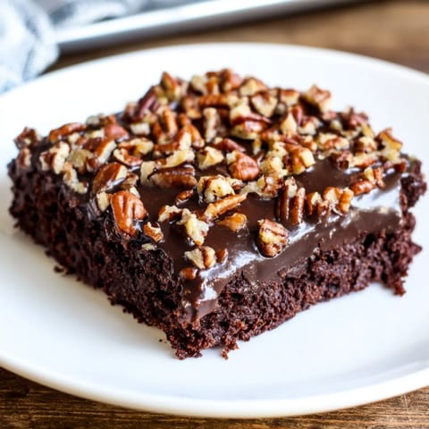 A homemade Texas Sheet Cake, rich chocolate flavor, with a perfect fudgy icing and pecans on top.
