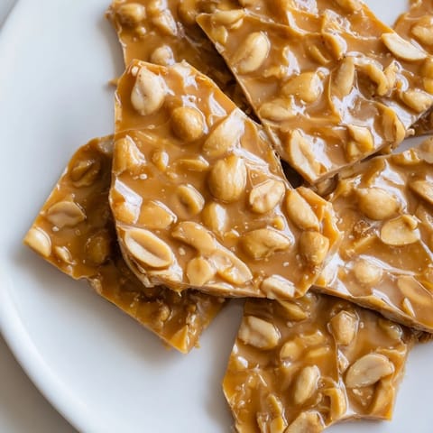 Crispy peanut brittle, a sweet treat showcasing golden toffee and crunchy peanuts ready to enjoy.