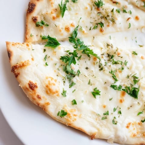 Golden-brown Creamy Garlic White Pizza with a crisp crust, loaded with bubbly mozzarella and rich garlic cream sauce.