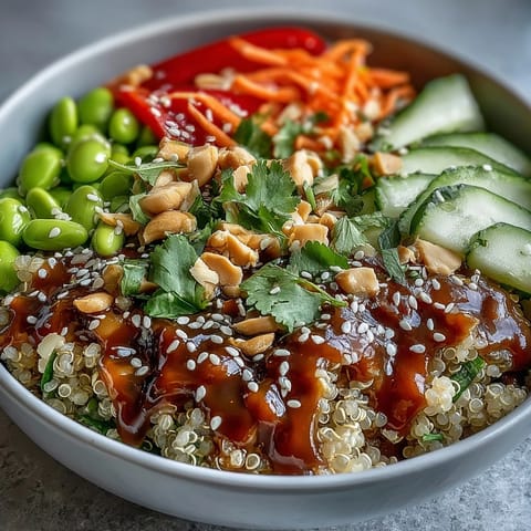 Colorful Thai Coconut Quinoa Bowl drizzled with creamy peanut dressing and sesame seeds.