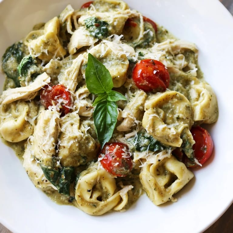 Savory Creamy Pesto Tortellini Skillet with wilted spinach and cherry tomatoes in a rich, bubbling sauce, ready to serve hot for dinner.