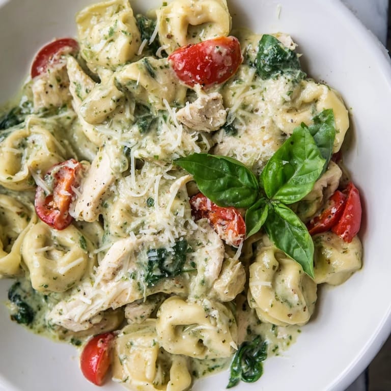 Juicy rotisserie chicken and cheese tortellini in a creamy pesto sauce, making a comforting Creamy Pesto Tortellini Skillet meal perfect for weeknights.