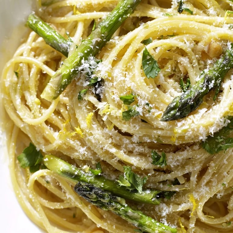 Served hot in a white bowl, this vegetarian Roasted Garlic & Asparagus Pasta garnished with fresh parsley and lemon zest.