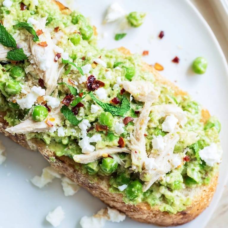 Tender shredded chicken mixed with creamy smashed peas on crisp toasted bread for a quick 20-minute meal.