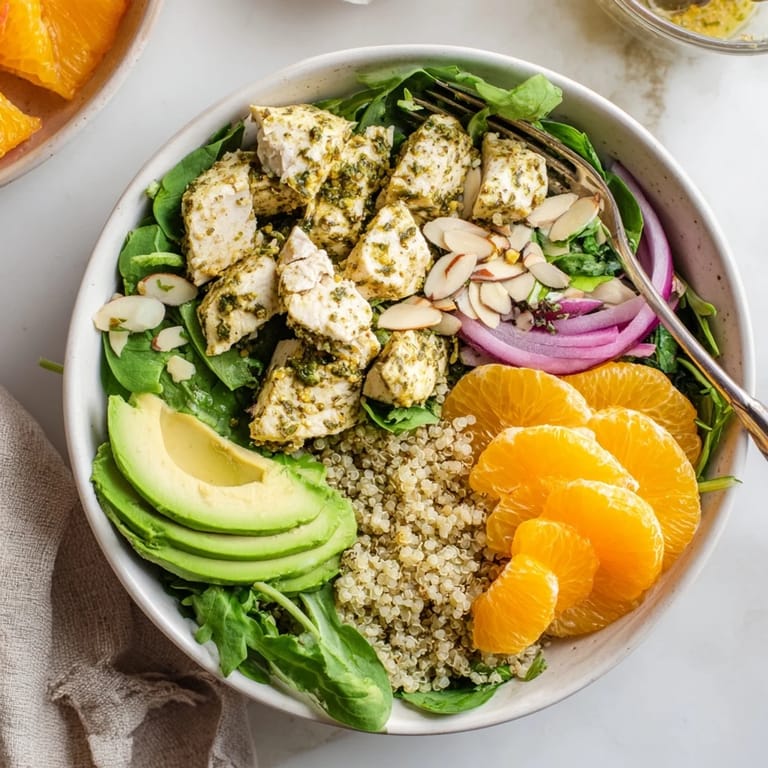 Enjoy a wholesome, gluten-free Citrus Herb Chicken Salad Bowl featuring fluffy quinoa, crisp vegetables, and tender grilled chicken slices.